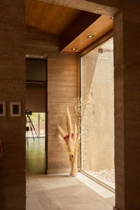 a vase with flowers in a room with a window at La Quebrada Potrerillos - Lodges de Montaña in Potrerillos