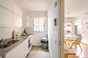a white kitchen with a sink and a table at Mi Lugar en Rosario - Depto céntrico VIP con cochera cubierta in Rosario +17 photos