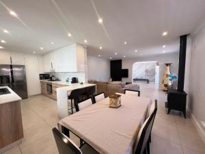een keuken en woonkamer met een tafel en stoelen bij Villa Lamsyh- your second home in Kaapstad