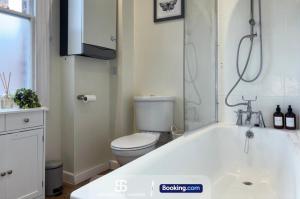 a white bathroom with a toilet and a tub at 3 Bedroom Stylish Oxford Townhouse Near The University By Spencer And Jackson Short Lets & Serviced Accommodation in Oxford