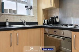 a kitchen with a sink and a stove at 3 Bedroom Stylish Oxford Townhouse Near The University By Spencer And Jackson Short Lets & Serviced Accommodation in Oxford +9 photos