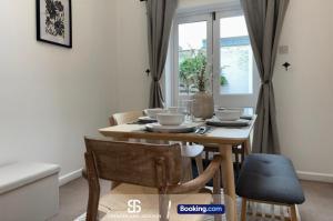 a dining room with a table and chairs and a window at 3 Bedroom Stylish Oxford Townhouse Near The University By Spencer And Jackson Short Lets & Serviced Accommodation in Oxford