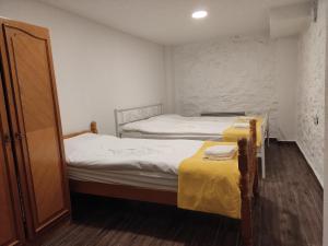 two beds in a small room with yellow sheets at Old Town Patio House in Ohrid