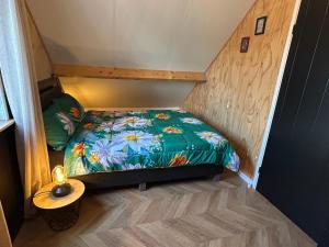 a small room with a bed in a tiny house at Tiny House Thuus in Sint Annaland