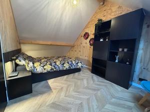 a bedroom with a bed and a wooden wall at Tiny House Thuus in Sint Annaland