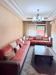 ein Wohnzimmer mit einem roten Sofa und einem Tisch in der Unterkunft Heart of Marrakech in Marrakesch