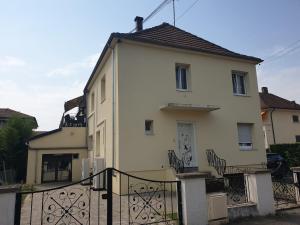 a white house with a black fence in front of it at family in Schiltigheim