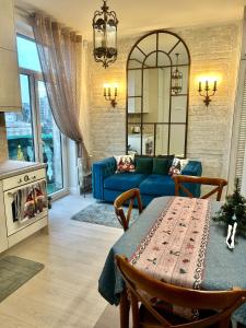 un salon avec un canapé bleu et une table dans l'établissement Spectacular river view apartment, à Vilnius
