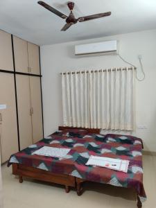 a bedroom with a bed and a ceiling fan at Place away from home in Hyderabad
