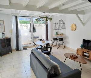 a living room with a couch and a table at Côté Baie avec parking-wifi- draps et serviettes in Hendaye