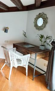 a desk with a chair and a mirror on a wall at Côté Baie avec parking-wifi- draps et serviettes in Hendaye +3 photos