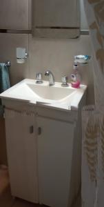 un lavabo blanco con una botella de jabón. en Lo de Pedro Tandil, en Tandil