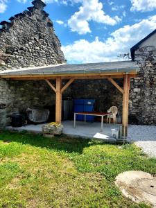 a pavilion with a picnic table and a stone wall at Maison de village au pied des Pyrénées in Marignac +17 photos