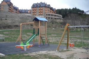 a playground with a slide and a swing set at Apartamento en Panticosa in Panticosa