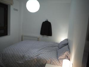 a bedroom with a bed and a black jacket hanging on the wall at Apartamento en Panticosa in Panticosa +18 photos