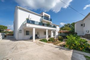 a white house with a large driveway at Apartment Sea Sponge in Brodarica