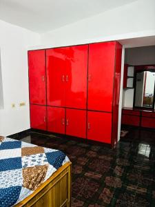 a red bedroom with a bed and red cabinets at LUXUS INN JA - Padmanabha in Trivandrum