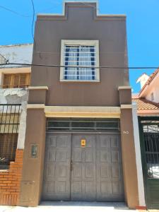 a house with a garage door in front of it at Depto. Centro Santiago del Estero in Santiago del Estero