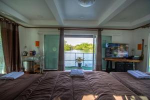 een slaapkamer met een groot bed en een groot raam bij บ้านกลางโดม Baan Klang Dome in Ban Huai Hai