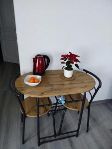 a table with a bowl of oranges and a plant on it at Bel appartement entier F1 à 5 mn de Mulhouse in Zillisheim