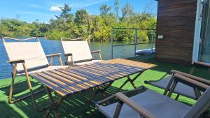 een picknicktafel en twee stoelen op een terras aan het water bij บ้านกลางโดม Baan Klang Dome in Ban Huai Hai +25 foto's