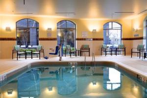 a pool in a hotel with chairs and tables at Courtyard by Marriott Columbus OSU in Columbus