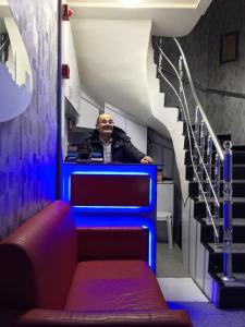 a man sitting at a counter in a room with stairs at Fatih Hotel Erciyes in Istanbul