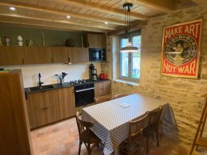 a kitchen with a table and a dining room at La maison Colombe in Molinot