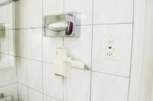 un bagno piastrellato bianco con doccia e spazzolino da denti di Gasthof zur Saline a Pratteln