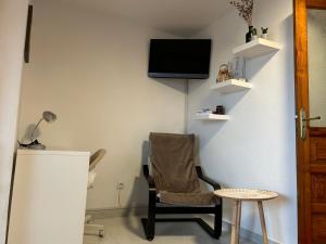 a room with a chair and a table and a tv at Casita Lola Sol in Puntillo del Sol