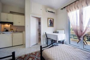 sala de estar con mesa y cocina con ventana en Penthhouse Studio next to the beach, en Suda