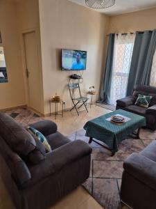 un soggiorno con divani e TV a schermo piatto di Appartement Caraïbe a Rufisque