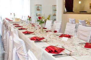 una larga mesa blanca con servilletas rojas y gafas en Gasthof zur Saline, en Pratteln