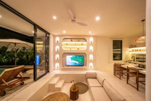 a living room with a couch and a tv at Villa Somnia Bliss Private One Bedroom Retreat in Tumbak Bayuh