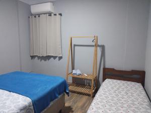a small room with two beds and a mirror at Apartamento São Vicente in São Vicente
