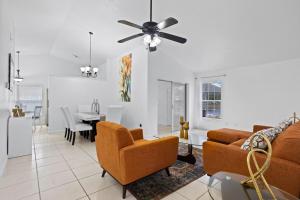 Una sala de estar con un sofá y sillas y una mesa. en APluSS Getaway, en Kissimmee