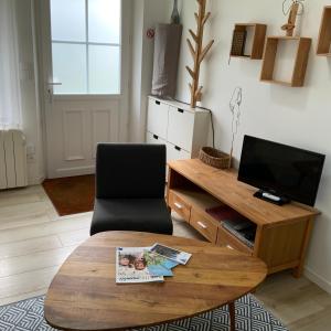 a living room with a coffee table and a television at La Maisonnette de Senlis in Senlis +28 photos
