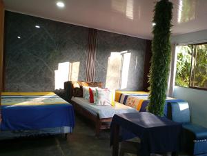 a room with two beds and a couch and windows at Mono titi third floor in Manuel Antonio