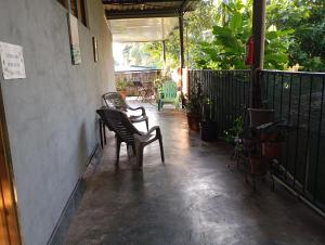 a patio with two chairs and a table and a fence at Mono titi third floor in Manuel Antonio