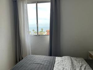 a bedroom with a bed and a window with a view at Casita Lola Sol in Puntillo del Sol