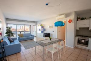 a living room with a table and a blue couch at Casa Adelaide - Vicino al mare, al centro, terrazza con vista in Senigallia