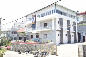 a white building with motorcycles parked in front of it at Jeyam Palace by Whynter Stays in Kodaikānāl