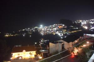 a view of a city at night with lights at Jeyam Palace by Whynter Stays in Kodaikānāl