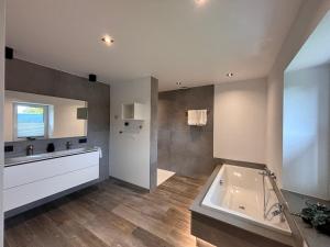 a bathroom with a tub and a sink at Hyronimus House in Amblève +57 photos