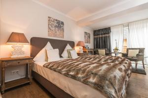 a hotel room with a large bed and a living room at Boardinghouse Robbe in Westerland +27 photos
