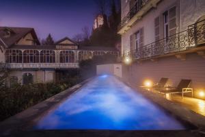 a swimming pool in front of a house at night at Belfry & Spa by Ligne St Barth in Lourdes