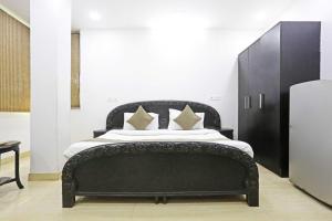 a bedroom with a black bed with white sheets and pillows at Hotel O The Premium Villla in New Delhi