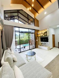 un soggiorno con un divano e un tavolo di Ploy Mountain View Pool Villa a Ban Thai Thai
