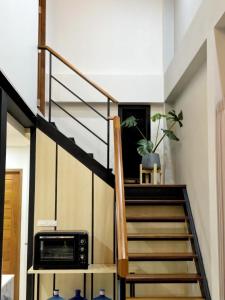 a staircase in a house with a microwave at Ploy Mountain View Pool Villa in Ban Thai Thai