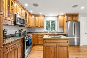 a kitchen with wooden cabinets and stainless steel appliances at Home in Oak Bluffs in Oak Bluffs
